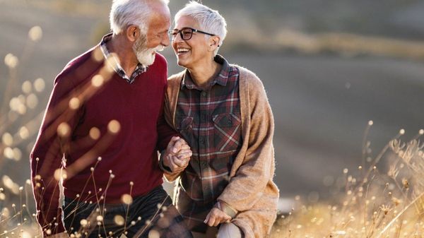 Es ist ein verliebtes und lachendes älteres Paar zu sehen.