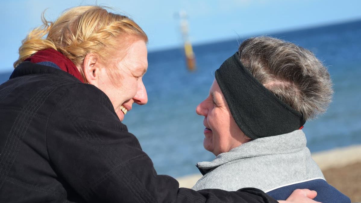 Zwei Frauen befinden sich am Meer während der kalten Jahreszeit.