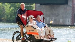 Ein Seniorenpaar genießt eine Malteser-Rikschafahrt in der Sonne.