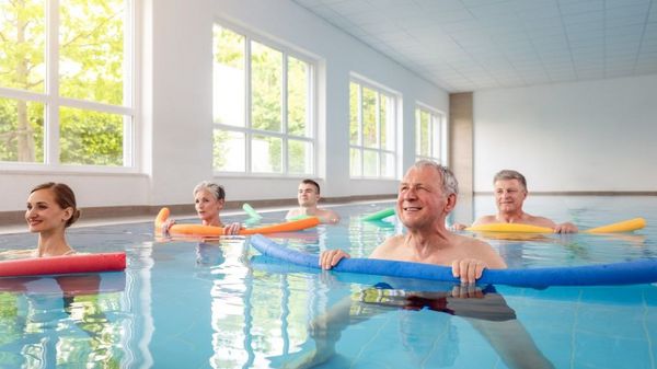 Ältere Menschen bei einer Wassergymnastik mit Pool-Nudeln.