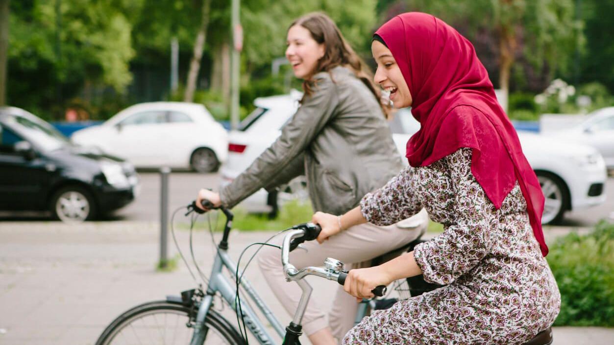Bike Bridge: zwei junge Frauen fahren auf dem Fahrrad