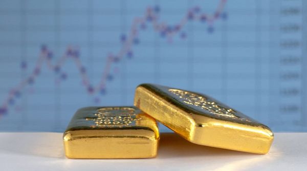 Es werden zwei Goldbarren gezeigt, die vor einem Aktienkurs gelegt wurden.