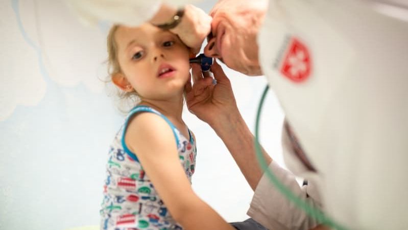 Ein junges Mädchen wird von einem Kinderarzt untersucht.