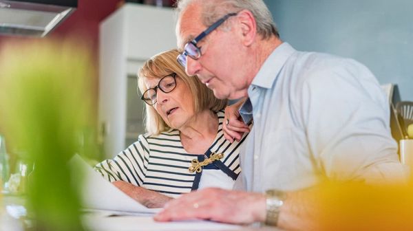 Ein Seniorenpaar kontrollieren ihre Finanzdokumente.