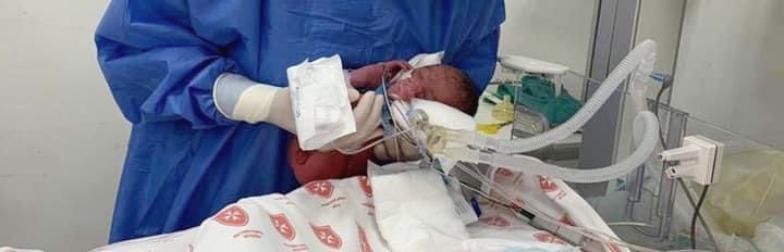 Ärztin hält ein frühgeborenes Baby auf einer Säuglingsstation